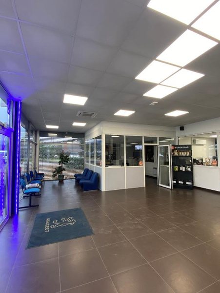 Espace d’accueil de Bédarieux Automobiles avec tapis Peugeot et salle d’attente